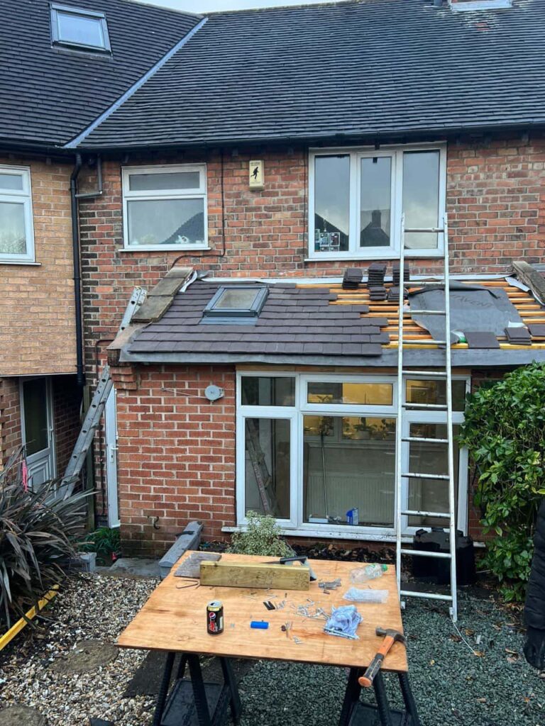 This is a photo of a roof extension that is having new roof tiles installed. This is a photo taken from the roof ridge looking down a tiled pitched roof on to a flat roof. Works carried out by Retford Roofing Repairs