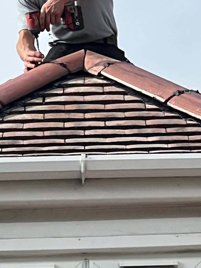 This is a photo of one of the operatives of Retford Roofing Repairs installing new ridge tiles