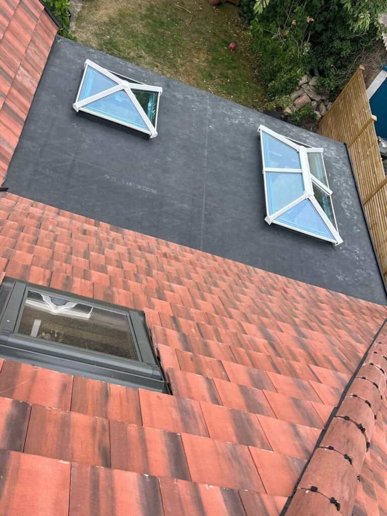 This is a photo taken from the roof ridge looking down a tiled pitched roof on to a flat roof. Works carried out by Retford Roofing Repairs